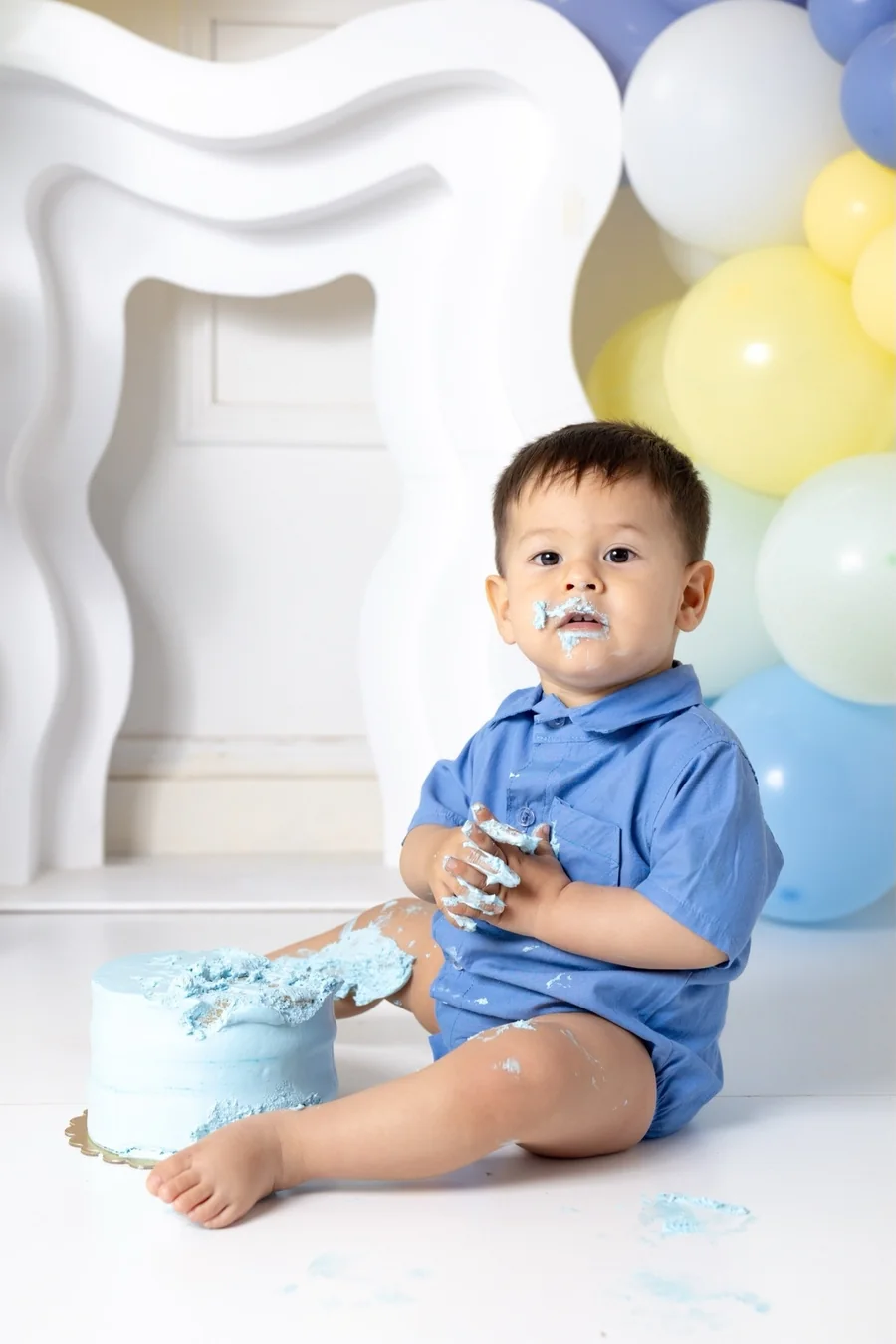 Bebé de un año con su torta azul en el estudio