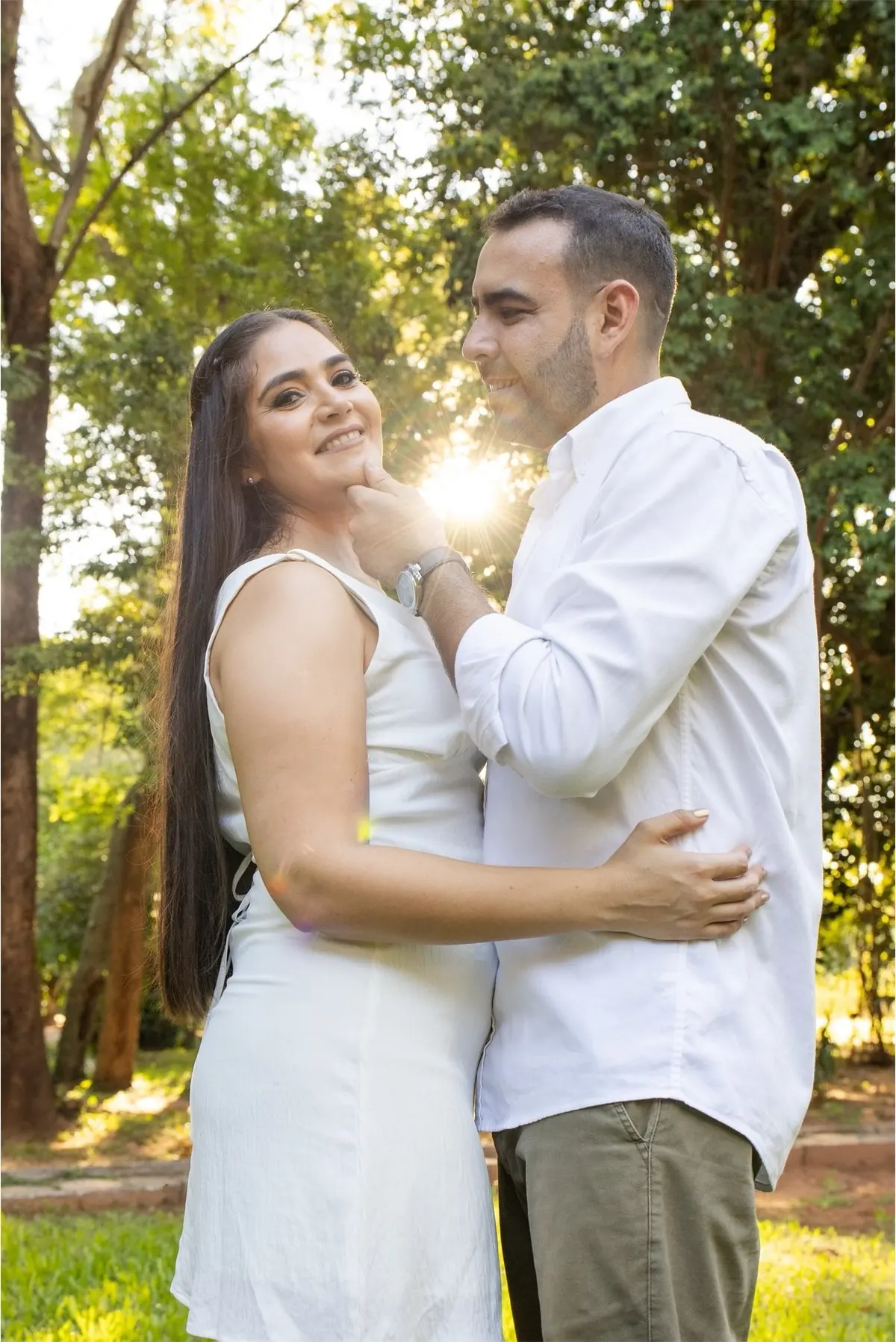 Pareja abrazada en un bosque con el sol de la tarde