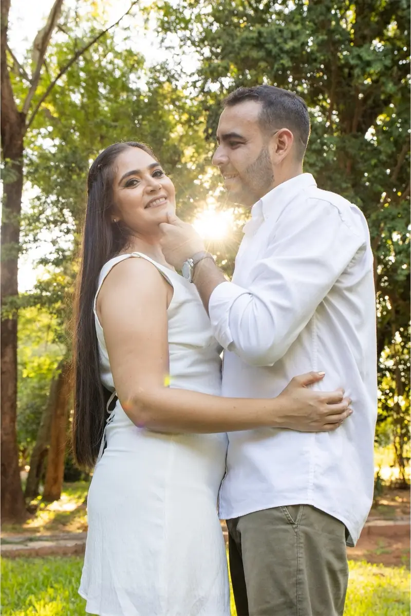 Pareja abrazada en un bosque con el sol de la tarde