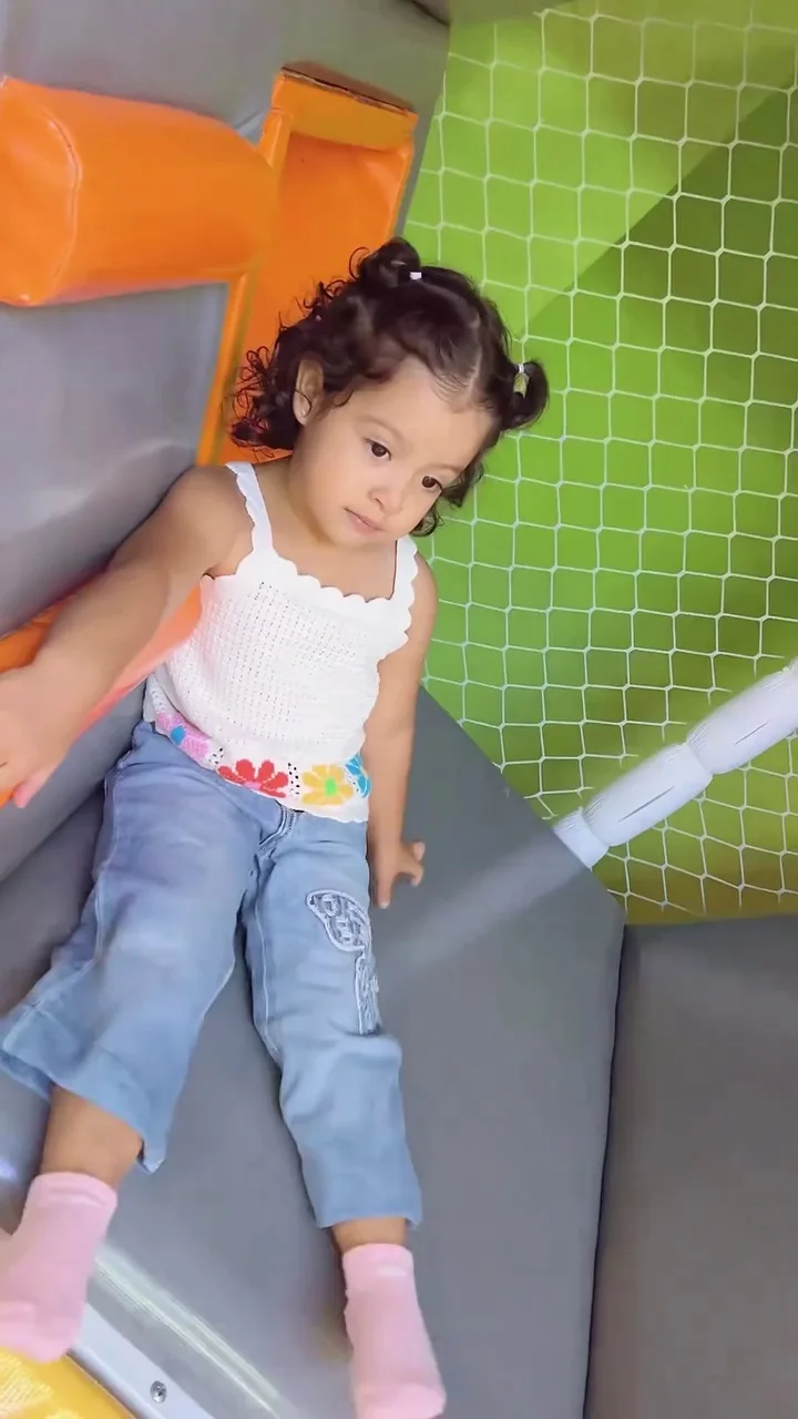 Niña jugando en un tobogán durante su cumpleaños